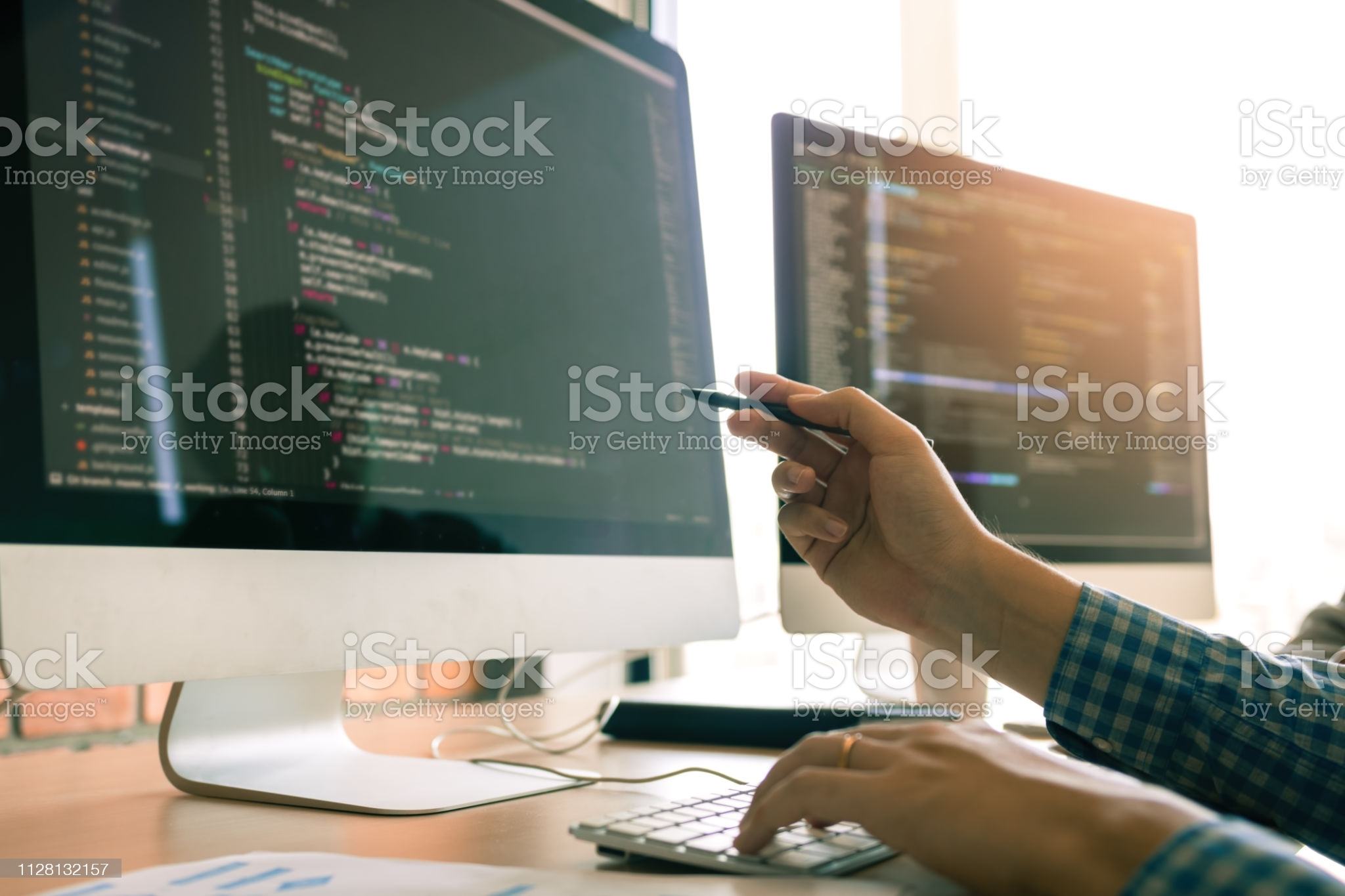 Developing programming working in a software engineers code tech applications on desk in office room.